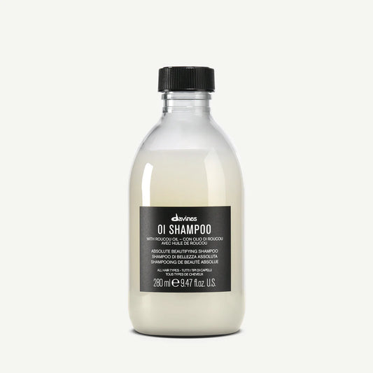 Bottle of Davines OI Shampoo with roucou oil for all hair types on a white background