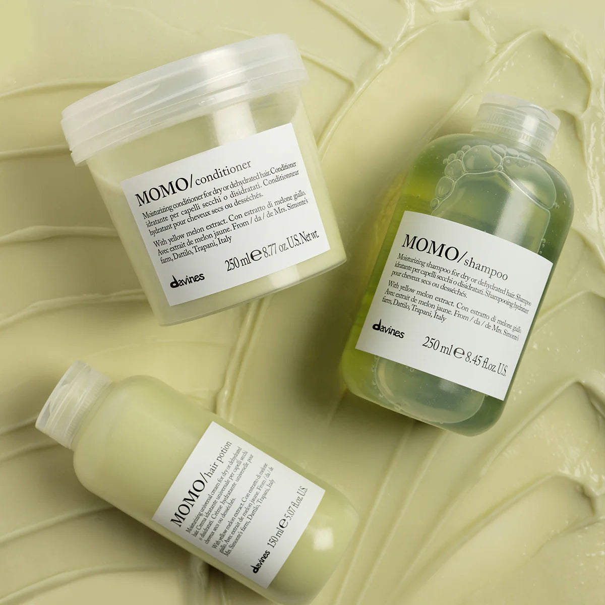 Three bottles of Davines MOMO moisturizing hair care products for dry or dehydrated hair